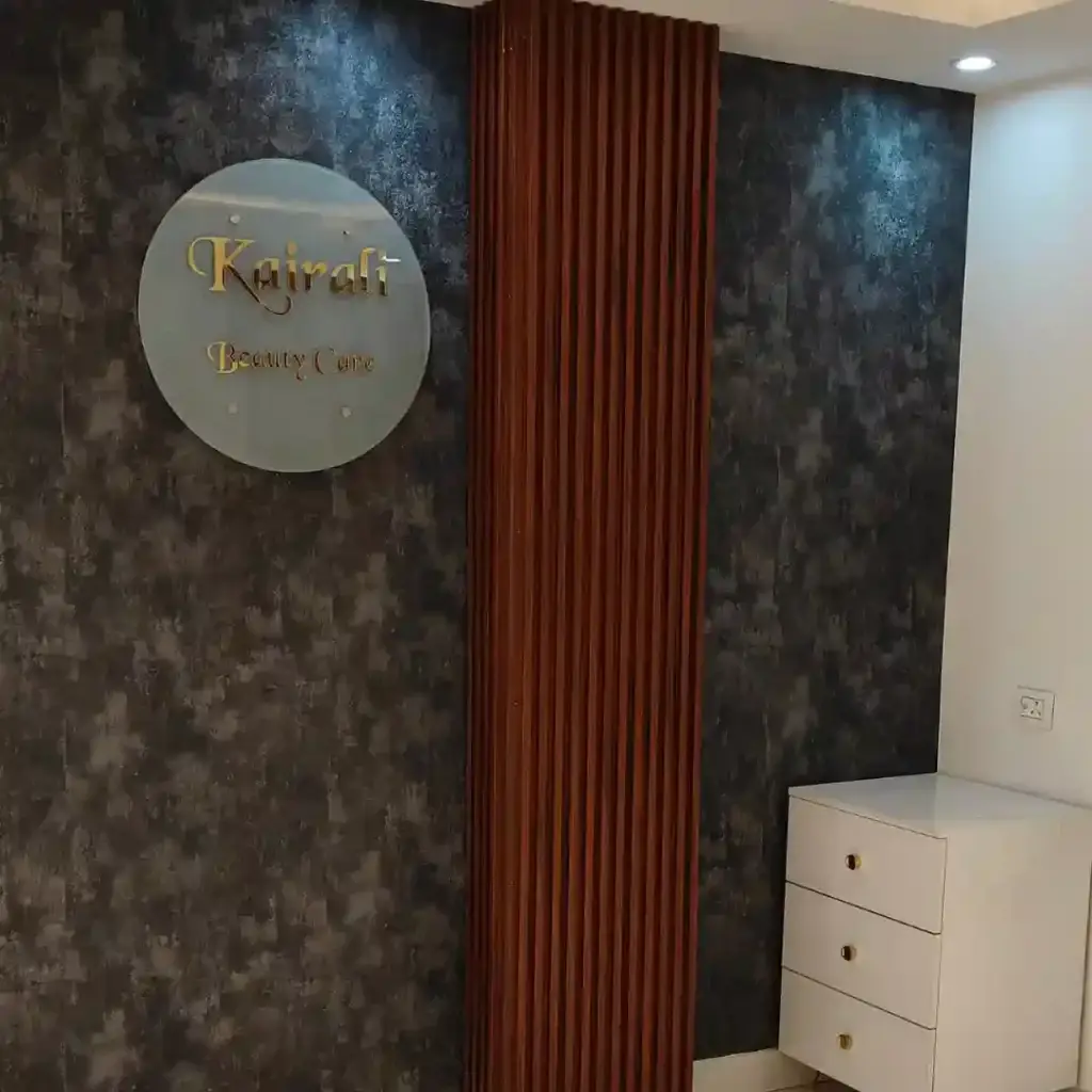 Modern salon reception area with a "Kairali Beauty Care" sign, textured wall, and wooden paneling, ideal for beauty spas in Delhi, Gurgaon, and Noida
