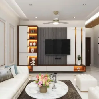 Modern living room with a TV wall, white sofa, marble table, and ambient lighting, ideal for homes in Delhi, Gurgaon, and Noida