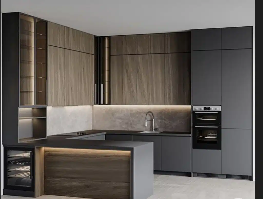 Modern luxury kitchen with dark wood and matte black cabinets, island with underlighting, built-in oven, and marble backsplash by Modular Kitchen DSI